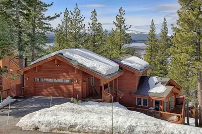 a log cabin with snow on the roof at Northstar Conifer Luxury Home home in Truckee