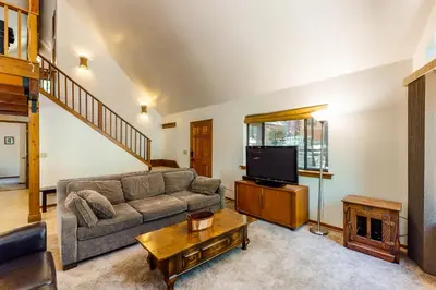 a living room with a couch and a tv at The Arrow House in Camp Connell