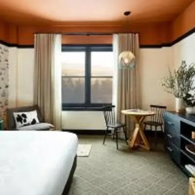 a hotel room with a bed and a table and a window at El Capitan Hotel in Merced