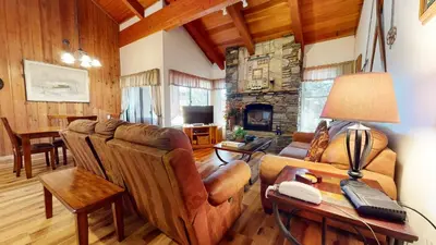 a living room with leather furniture and a stone fireplace at Val D'Isere #17 condo in Mammoth Lakes