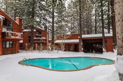 a swimming pool in the snow in front of a house at Woodlands #25 condo in Mammoth Lakes