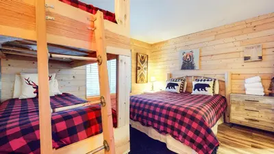 two bunk beds in a room with wooden walls at Forest Creek #29 condo in Mammoth Lakes