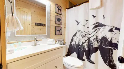 a bathroom with a shower curtain with a dog on it at Forest Creek #29 condo in Mammoth Lakes