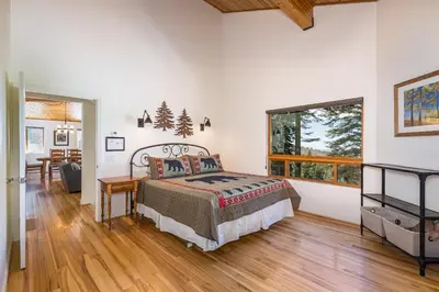 a bedroom with a bed and a desk and a window at Canyons Crest in Yosemite West