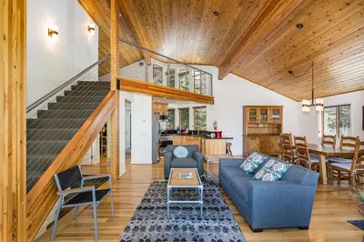 a living room with a blue couch and a staircase at Canyons Crest in Yosemite West