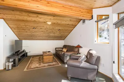 a living room with leather furniture and wooden ceilings at Canyons Crest in Yosemite West