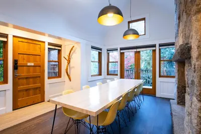 a dining room with a wooden table and yellow chairs at Cedar Crest - Eagle Cottage 8 in Homewood