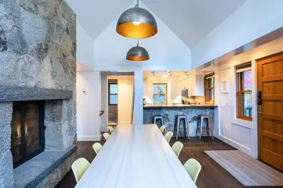 a long table in a room with a stone fireplace at Cedar Crest - Eagle Cottage 8 in Homewood
