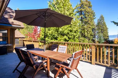 a wooden table and chairs with an umbrella on a deck at Cedar Crest - Eagle Cottage 8 in Homewood