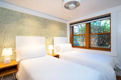 two beds in a bedroom with a window at Cedar Crest - Mallard Cottage 5 in Homewood
