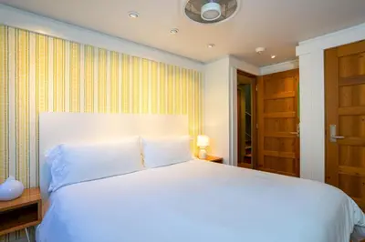 a bedroom with a large white bed and a window at Cedar Crest - Mallard Cottage 5 in Homewood
