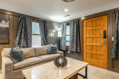 a living room with a couch and a table at Cedar Crest - Osprey Cottage 3 in Homewood