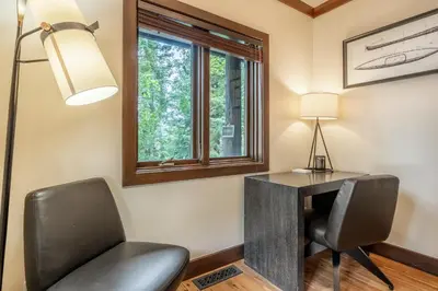 a desk and a chair in a room with a lamp at Cedar Crest - Owl Cottage 9 in Homewood