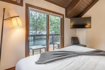 a bedroom with a bed and a view of a balcony at Cedar Crest - Owl Cottage 9 in Homewood