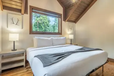a bedroom with a large white bed and a window at Cedar Crest - Owl Cottage 9 in Homewood