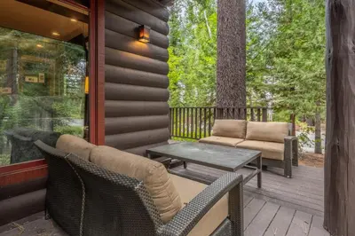 a porch with chairs and a table and a tree at Cedar Crest - Owl Cottage 9 in Homewood