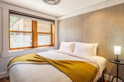 a bedroom with a bed with a yellow blanket on it at Cedar Crest - Robin Cottage 6 in Homewood