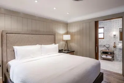 a bedroom with a large white bed and a bathroom at Cedar Crest - Sparrow Cottage 1 in Homewood