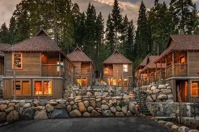 a large house with a stone wall in front at Cedar Crest - Woodpecker Cottage 7 in Homewood