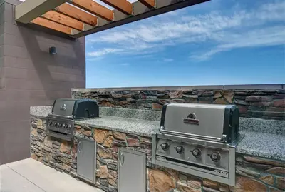 a outdoor kitchen with two stoves on a stone wall at Home2 Suites By Hilton Tracy, Ca in Tracy