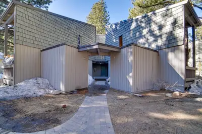 a house with two garage doors and a driveway at Resort Condo with Hot Tub and Pool, Near Ski Lift in Mammoth Lakes