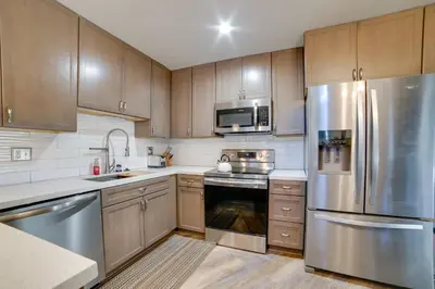 a kitchen with wooden cabinets and stainless steel appliances at Resort Condo with Hot Tub and Pool, Near Ski Lift in Mammoth Lakes