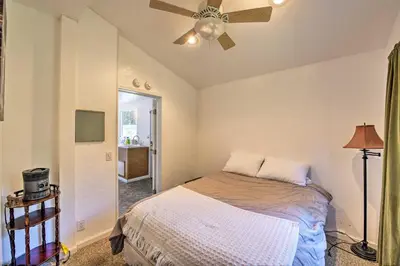 a bedroom with a bed and a ceiling fan at Secluded Camp Connell Home with Deck and Fireplace! in Camp Connell