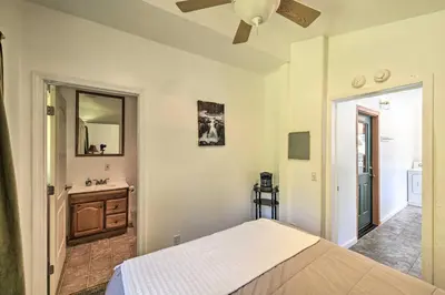 a bedroom with a bed and a sink and a mirror at Secluded Camp Connell Home with Deck and Fireplace! in Camp Connell
