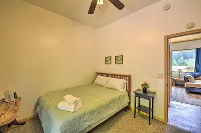 a bedroom with a bed and a living room at Secluded Camp Connell Home with Deck and Fireplace! in Camp Connell
