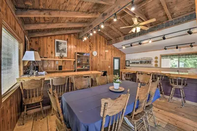a dining room with a blue table and chairs at Secluded Camp Connell Home with Deck and Fireplace! in Camp Connell
