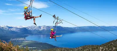 three people on a zip line over a lake at LUXE 15 Blue Diamond Lodge Lake Tahoe Hot Tub in Stateline