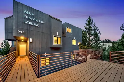 a black building with a wooden deck with a door at LUXE 15 Blue Diamond Lodge Lake Tahoe Hot Tub in Stateline