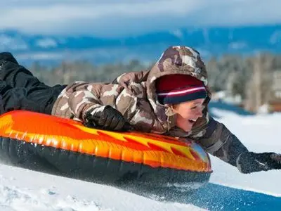 a young child is riding a snowboard in the snow at LUXE 4 Blue Diamond Lake Tahoe Lodge in Stateline