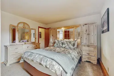 a bedroom with a bed and a dresser and mirror at Whispering Pines in Shaver Lake