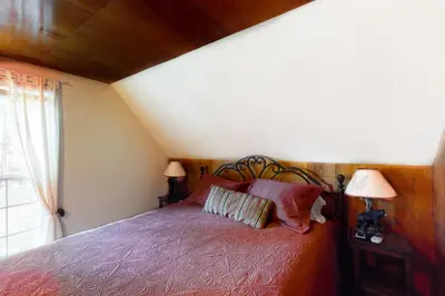 a bedroom with a bed with two lamps and a window at Maul Cabin in Shaver Lake