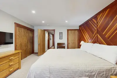 a bedroom with a large bed with a wooden headboard at Private Beach Retreat in Zephyr Cove