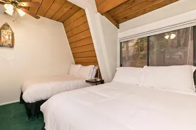 two beds in a room with a window at Bigwood 32 in Mammoth Lakes