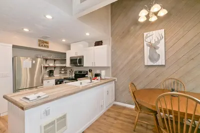 a kitchen with a table and a dining room at Bigwood 32 in Mammoth Lakes