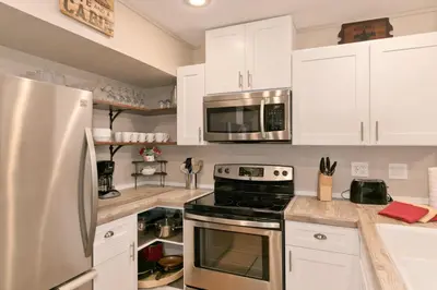 a kitchen with white cabinets and a stove and microwave at Bigwood 32 in Mammoth Lakes