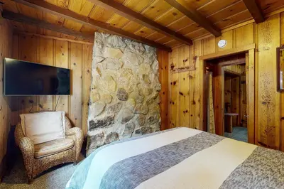 a bedroom with a bed and a stone wall at Tahoe Delight in Tahoe City
