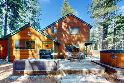 a log cabin with a patio in the woods at Tahoe Delight in Tahoe City