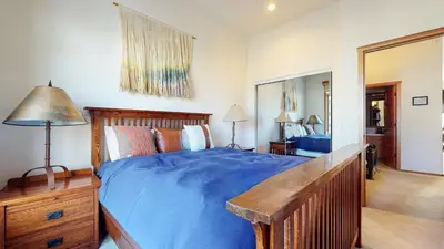 a bedroom with a blue bed and a mirror at Snowcreek #760 condo in Mammoth Lakes