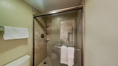 a bathroom with a shower with white towels at Spacious 3 Bed 3 Bath Condo with Pool in Mammoth Lakes