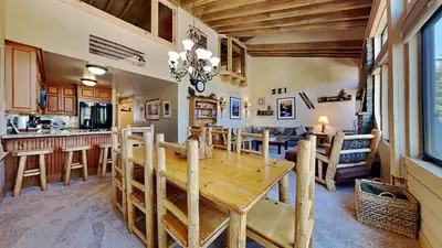 a dining room and kitchen with a wooden table at Beautiful 2 BR with 2 Lofts SLOPESIDE! in Mammoth Lakes