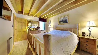 a bedroom with a large bed and a wooden ceiling at Beautiful 2 BR with 2 Lofts SLOPESIDE! in Mammoth Lakes