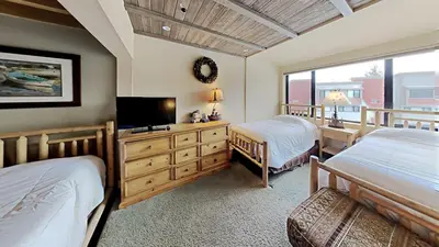 a bedroom with two beds and a flat screen tv at Beautiful 2 BR with 2 Lofts SLOPESIDE! in Mammoth Lakes