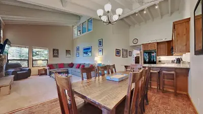 a kitchen and living room with a table and chairs at Spacious 4 Bed 3 Bath Condo Great For Families! in Mammoth Lakes