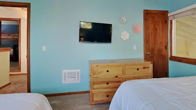 a bedroom with a bed and a dresser and a television at Spacious 4 Bed 3 Bath Condo Great For Families! in Mammoth Lakes
