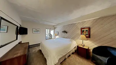 a bedroom with a bed and a chair and a television at Fantastic 3 Bedroom Condo with Great Views in Mammoth Lakes