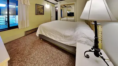 a bedroom with a bed and a table with a lamp at Amazing 2 Bedroom Condo with Awesome View! in Mammoth Lakes
